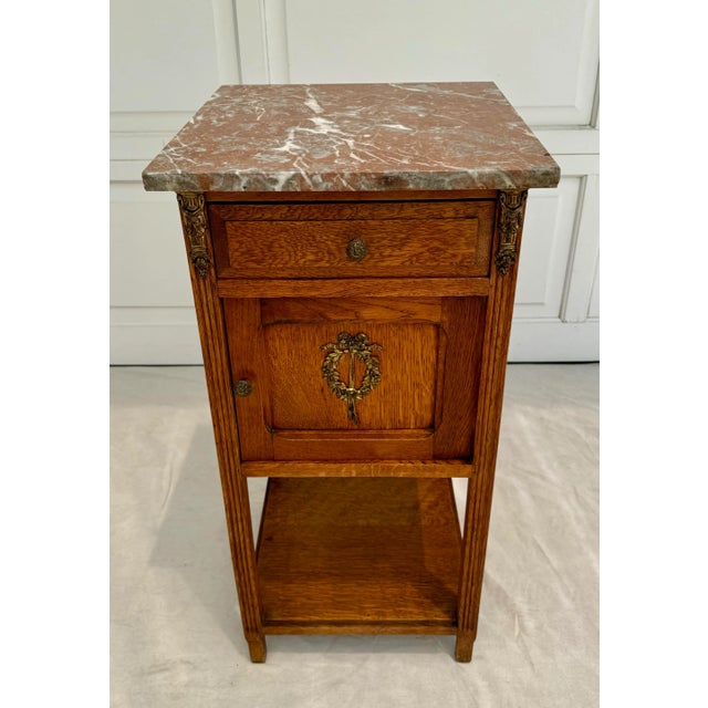 Here is a lovely, bedside cabinet or side table in the French Art Deco/Louis XVI style with a solid wood (I believe oak)...