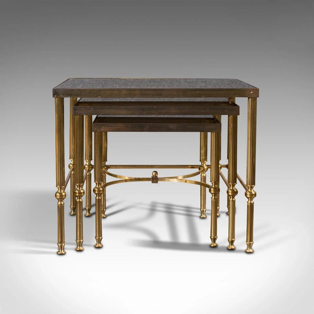 This is a trio of vintage nest tables. A French, brass and glass occasional or coffee table, dating to the late 20th...