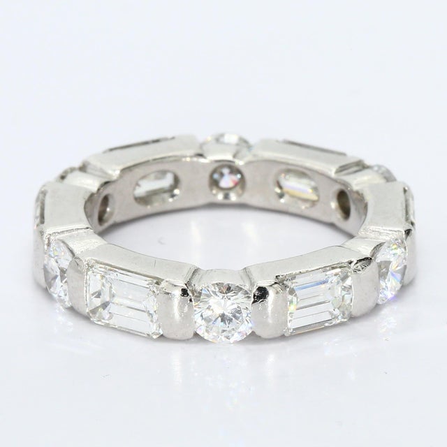 Here is a Platinum Band Ring featuring Emerald Cut White Diamonds totaling 0.25ct. D/VS1 and Round Cut White Diamonds...