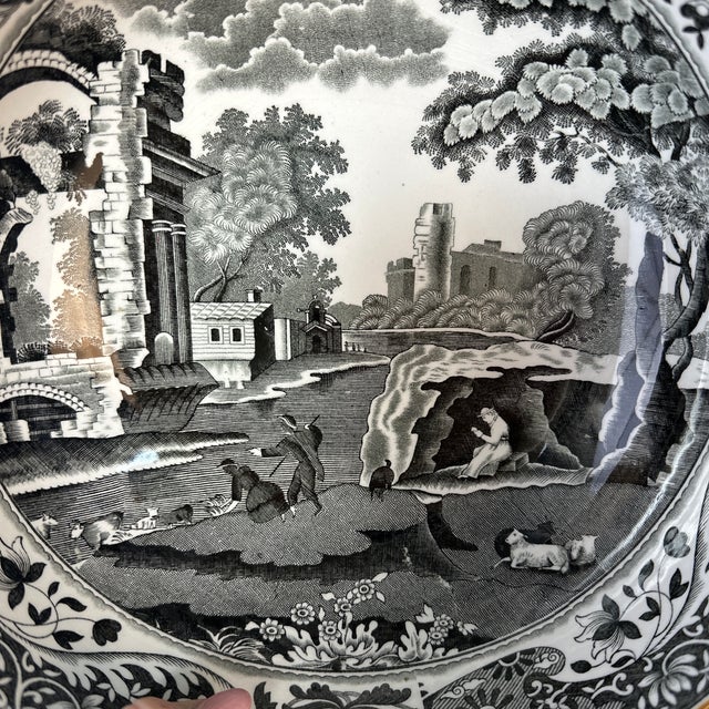 This bowl feels like a quiet relic from another century — elegant, narrative, and softly dramatic. Rendered in black and...