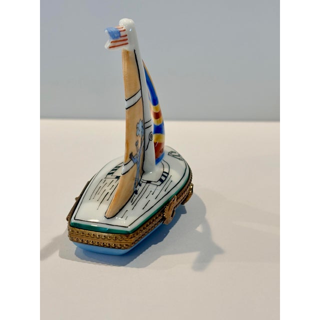 This Limoges Sailboat Trinket Box is a small, hand-painted collectible made of porcelain and bone china. It is part of the...