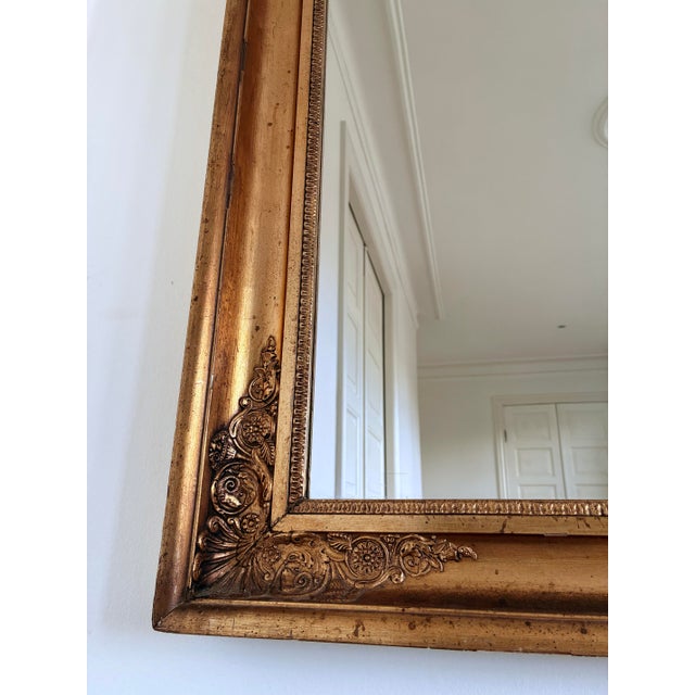 A 19th-century French wall mirror in Napoleon III style. This large mirror features a rectangular giltwood frame with...