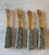 Set of 4 vintage serving spreader knives with marble stone handles and golden metal blades.