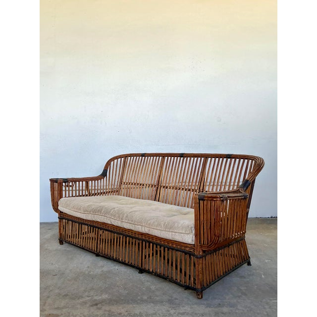 This vintage stick rattan sofa is a striking homage to the legendary designs of the Bielecky Brothers, capturing a...