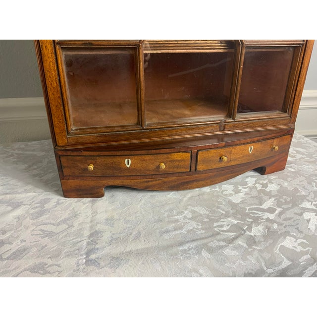 An attractive small size Georgian Mahogany display cabinet with fixed shelves and a fitted fabric interior. Decorative...