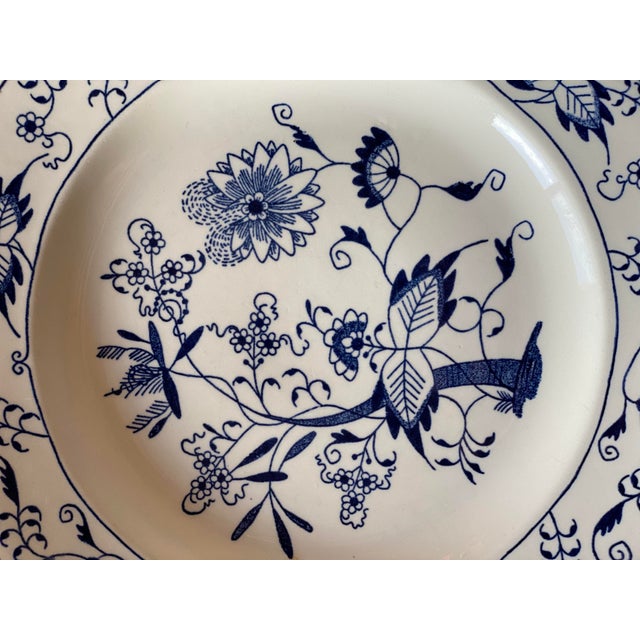 This is a 10" blue onion dinner plate in the DOORN pattern by Royal China (USA) with a blue underglaze.
