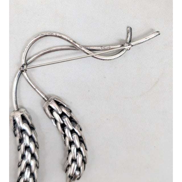 1950s silvertone two interlocking wheat sheafs on a twisted stem brooch with security clasp. Marked "NAPIER©" on the back...