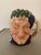 Royal Doulton Character Jug, Bacchus D6505 dressed in maroon robes; green leaves and purple grapes adorn the head....