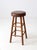 This classic vintage bar stool features a wooden frame with clean lines and a warm brown faux leather cushion seat. Ideal...