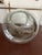 This clear glass jar features a rounded, pot-belly silhouette with a jute rope handle secured by polished metal clasps,...