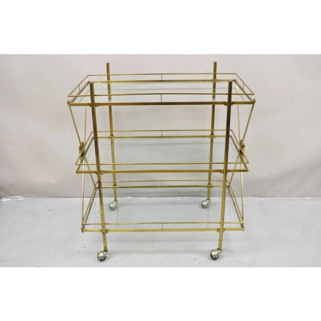 Vintage Mid Century Italian Modern 3 Tier Brass & Glass X-Frame Rolling Server Bar Cart Table. Circa Mid 20th Century....