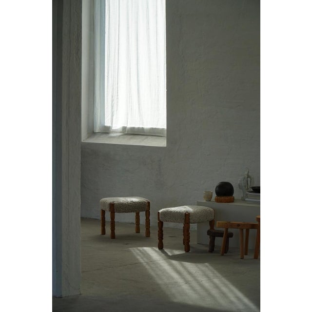 A beautifully crafted pair of stools, footstools, or ottomans in solid oak, each featuring a generously upholstered seat...