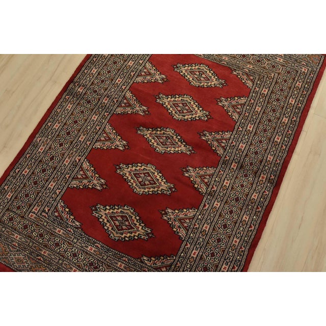 A tribal Bokhara Jaldar rug hand-knotted with fine wool on a cotton foundation. This rug features geometric medallions set...