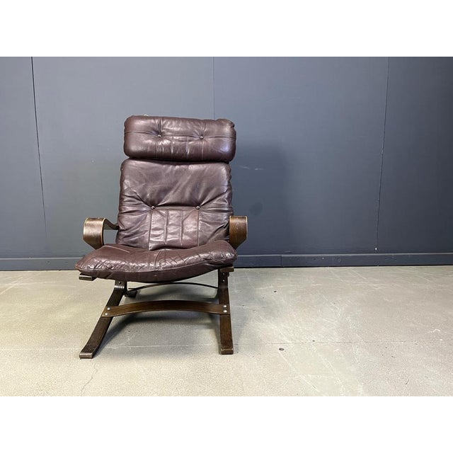 Vintage norwegian lounge chair with brown leather cushions and bent wood beech frame. The chair is very comfortable and...