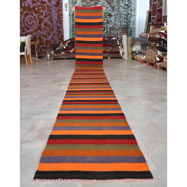 Woven in the 1970s in the Eskişehir region of Central Anatolia, this extra-long Turkish kilim runner brings a bold stripe...