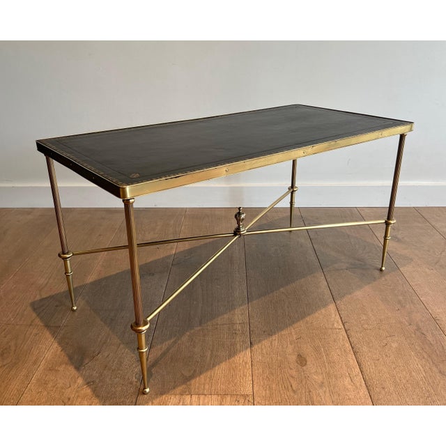 This very sleek and elegant neoclassical style coffee table is made of brass with a black leather top. It is a French work...