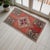 This charming small vintage rug features a warm terracotta field anchored by a striking central geometric medallion,...