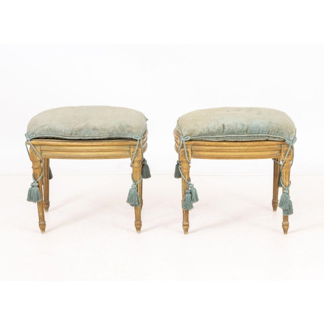 Pair of Louis XVI Style Upholstered Foot Stools, blue-grey cushion with tassels, carved wood frame with floral motif,...