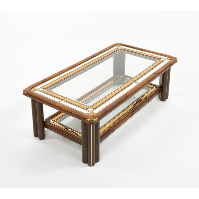 Midcentury amazing rectangular coffee table in wood, leather, glass, brass and mirror. The structure is made of wood with...