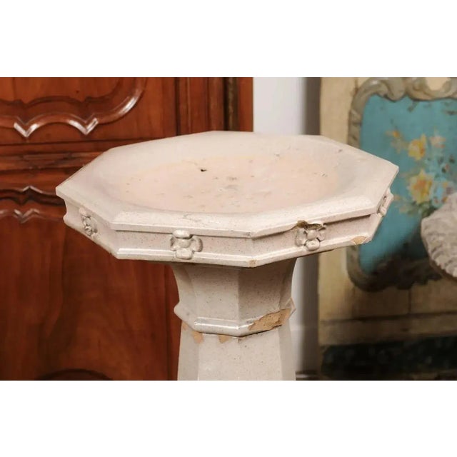 An English turn of the century glazed pottery bird bath from the early 20th century, with octagonal top, carved flowers,...