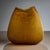 Large vase in amber-colored glass with a finely textured surface and gently flattened, bulbous form.