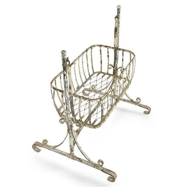 A testament to the refinement of 19th-century bourgeois interiors, this wrought-iron cradle captivates with the delicacy...