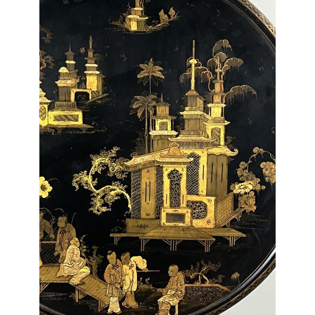 A superb folding side table in black lacquered wood, richly decorated with a Japanese-style gilt motif. The circular...
