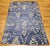 A vintage Mid-Century Moroccan room size rug was hand-woven in an all-over geometric pattern. The rug's main field is a...