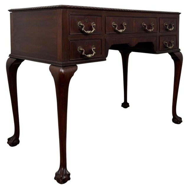 An elegant and beautifully crafted early 20th-century English Edwardian writing table, constructed in richly coloured...