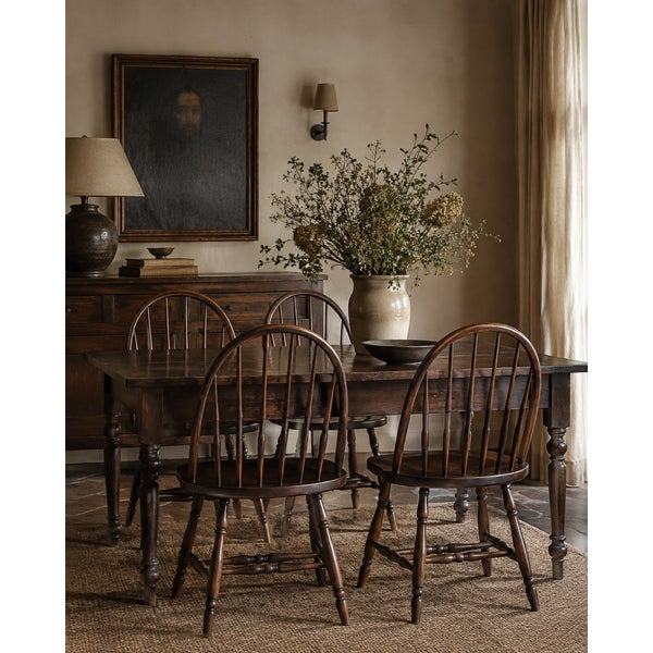 A set of four antique Windsor-style dining chairs, showcasing the enduring appeal of classic American furniture design....