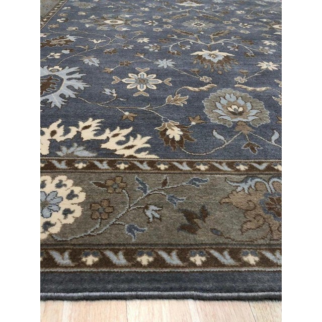 This gray wool rug features a hand knotted pile weave type, offering a durable floor covering option for residential...