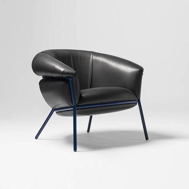 An iron tubular (25mm) structured armchair. Seat and backrest upholstered in leather. The leather upholstery oozes over...