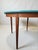 A 1960s table with a top painted with a professional, stain- and scratch-resistant teal satin PU lacquer. The veneer on...