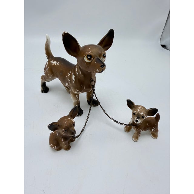 This is a charming vintage ceramic Chihuahua figurine set, featuring a larger mother dog accompanied by two tiny pups. The...