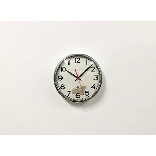 Wall clock produced by TN Telefonbau und Normalzeit in Germany during the 1960s. It features a silver chrome plated iron...