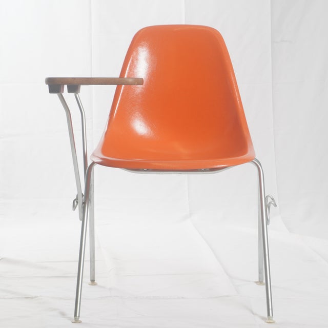 A mid-century design icon, this vintage Herman Miller shell chair with an integrated table combines functionality with...