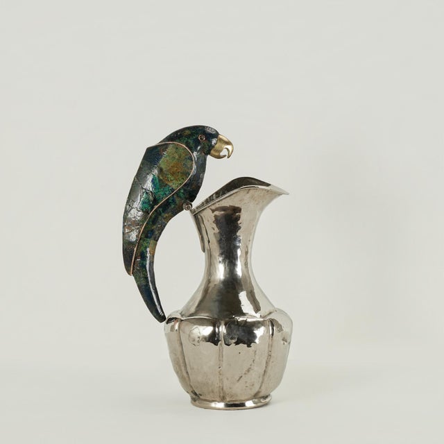 Striking mid-century pitcher handcrafted in silver plate over hammered copper in a sculptural modernist form, featuring a...