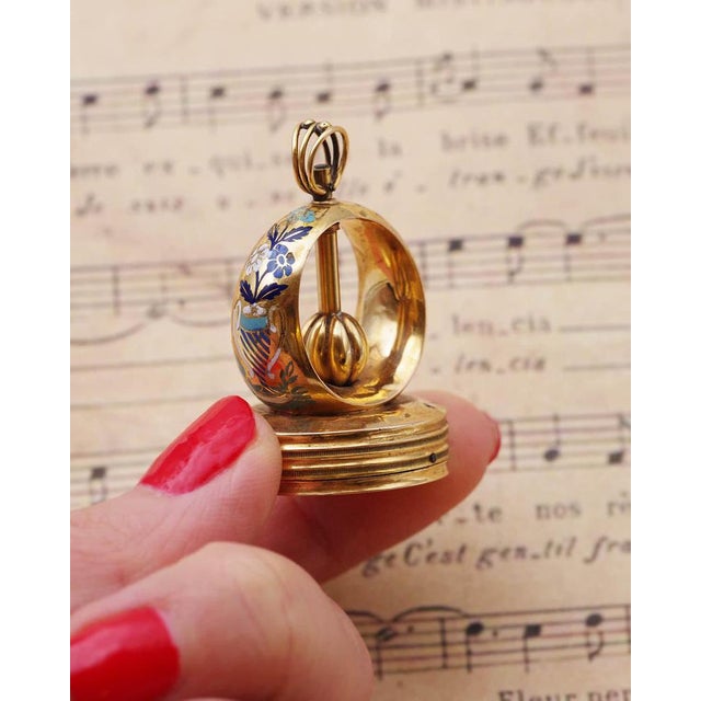 Swiss gold musical fob seal in 18 karat gold. Antique seal decorated with champlevé enamel flowers in a vase, in light...