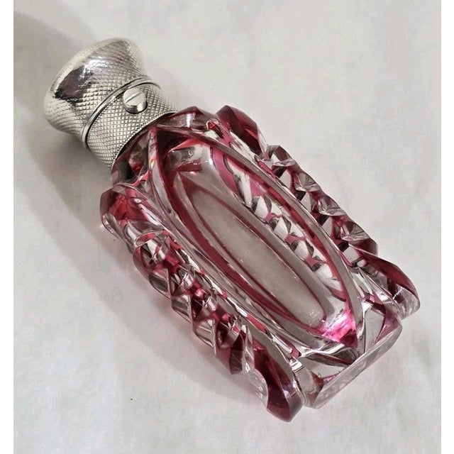A fine Victorian Bohemian cut glass vanity scent bottle, combining richly faceted glass with an elegant sterling silver...