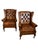 A handsome pair of vintage English wingback armchairs in cognac-brown leather with deep-button tufting and nailhead trim....
