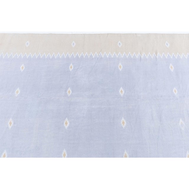 This vintage 1952 Indian Dhurrie rug presents a refined balance between traditional craftsmanship and understated mid-...
