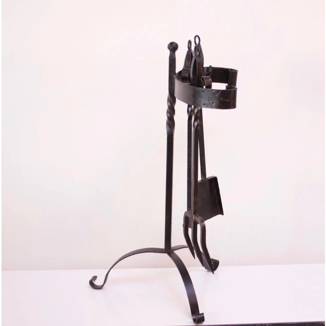 Mexican forged iron firetools consisting of a shovel, poker, fork, and holder, circa 1970s. Firetool holder itself is...