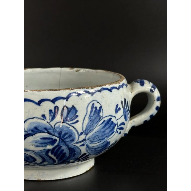 An authentic example of early Dutch Delftware, this two-handled faience bowl features hand-painted cobalt decoration over...