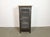 An iron cabinet from the 1960s features an iron structure, mesh doors, a wooden top and three wooden shelves inside the...