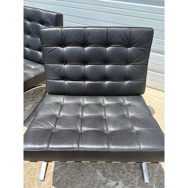 This is a pair of iconic Barcelona chairs designed by Ludwig Mies Van der, Rohe and Lily Reich. These chairs feature and X...