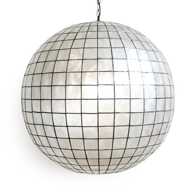 Stunning contemporary globe lantern made from delicate capiz shell square pattern bonded together with pewter finish...