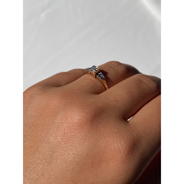 The 83rd Street: Retro Era Diamond Promise Ring. The ring features a central round diamond in a diamond-cut square mystery...