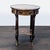 Antique side table using multiple woods with center inlay of birds, surrounded by metal trim. The table rests on curved...