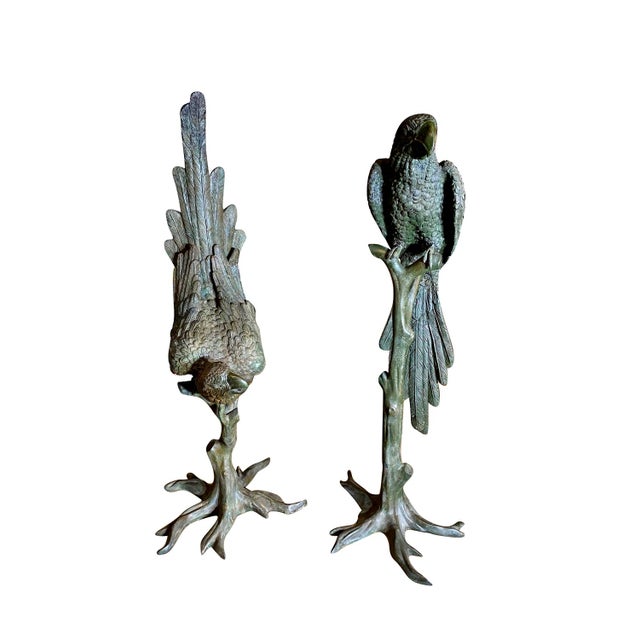 An impressive pair of monumental patinated bronze sculptures depicting exotic parrots perched upon naturalistically...