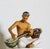 Large Glazed Porcelain figurine" Bantang" of an Indonesian boy wearing a patterned kerchief and playing a sitar, designed...